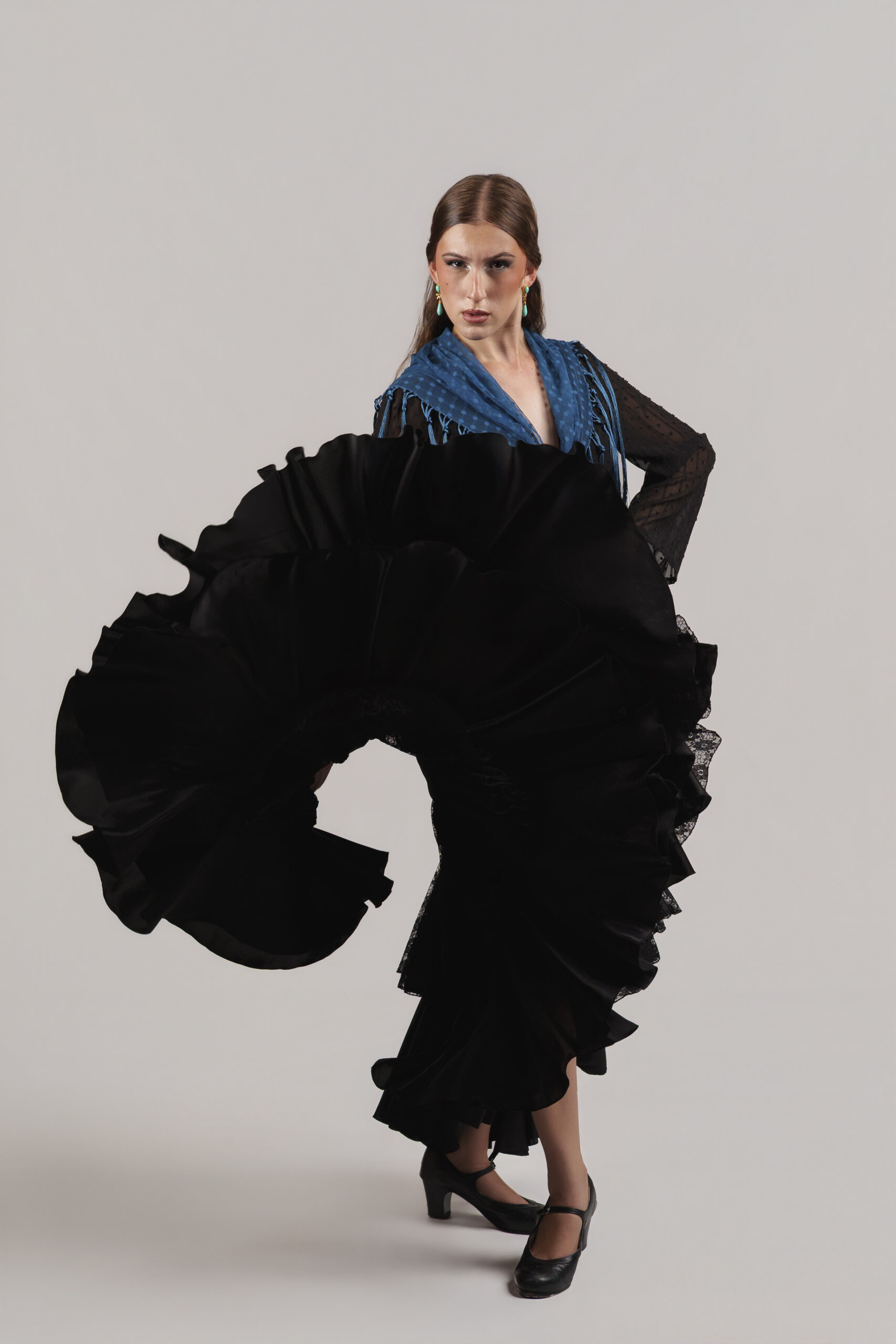 Marisa Adame, bailaora flamenca con traje morado, flor en el pelo y volantes de lunares durante una actuación.