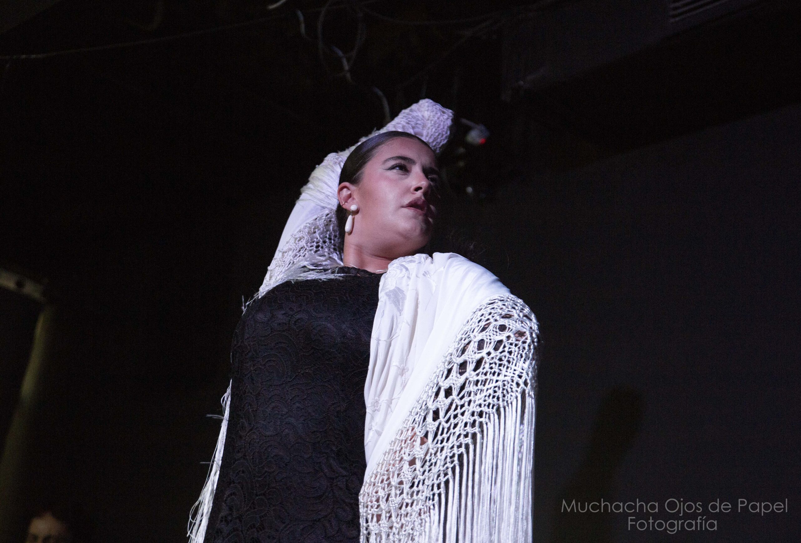 Carlos Ruiz, bailaor flamenco, vestido de negro y con los brazos levantados en una pose de baile.